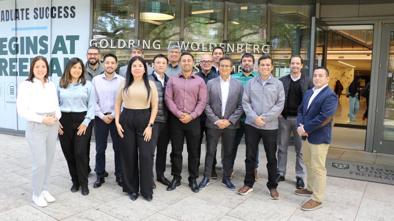 Goldring Institute for International Business students standing outside the front entrance of the Goldring/Woldenberg Business Complex in 2025.