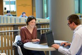 students seated at a table in the GWBC using computers