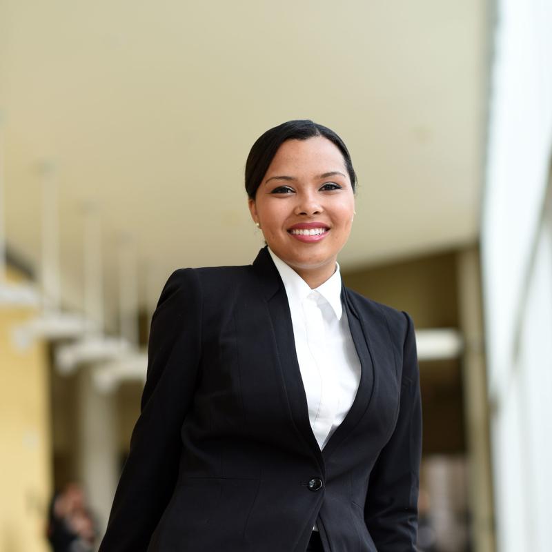 a Tulane Student in business attire inside the Goldring/Woldenberg Business Complex.