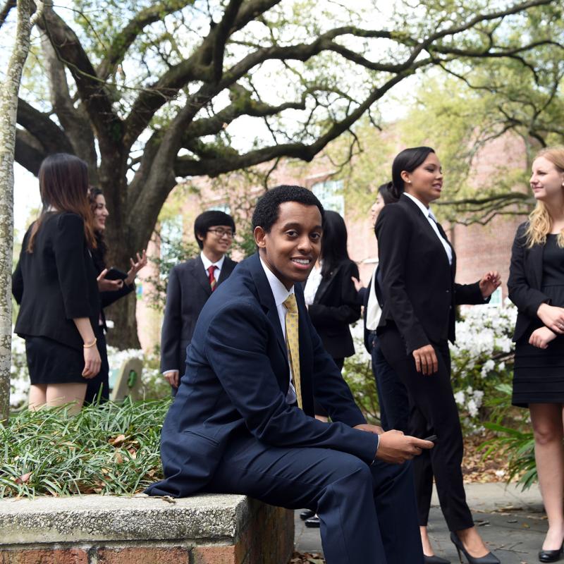 Tulane students gathered in a Goldring/Woldenberg Business Complex court yard engaged in group conversations.