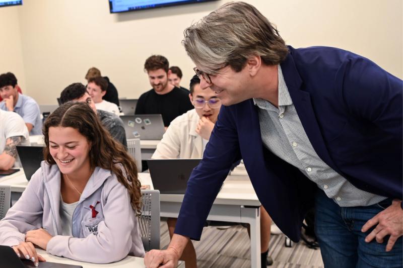 photo of AJ Brooks speaking with a student during a class