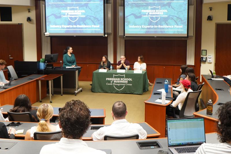 Members of Freeman's Industry Experts-in-Residence speak on a panel in a classroom full of Tulane students.