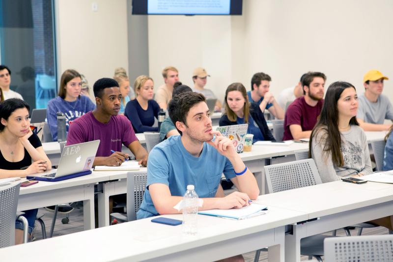 Students in a classroom listen attentively to a lecture.