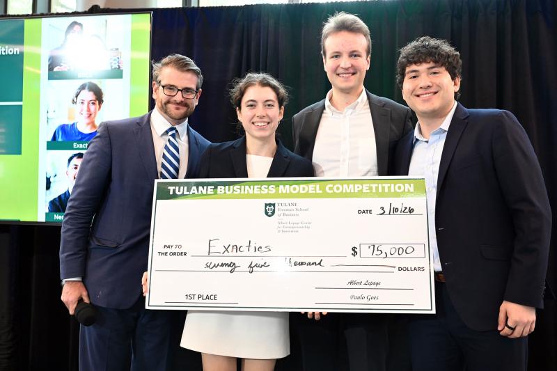 Rob Lalka and the founders of Exactics smiling and holding a giant check for $75,000 from Tulane Business Model Competition.