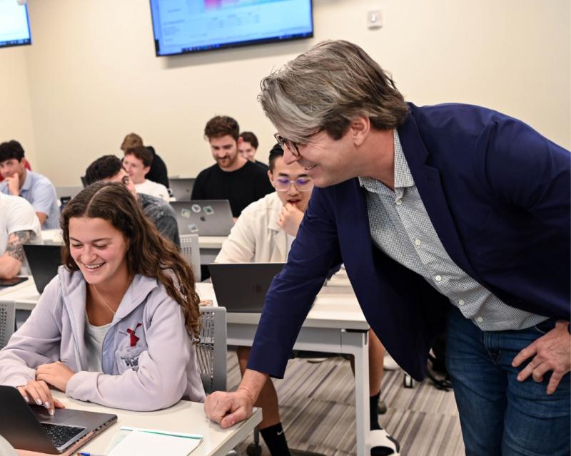 photo of AJ Brooks speaking with a student during a class