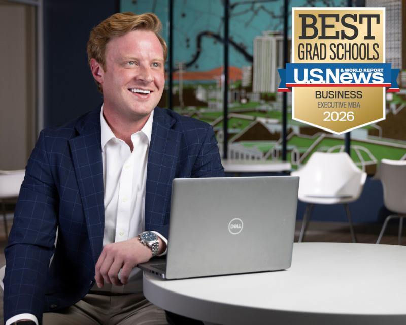 Tulane Freeman School of Business Executive MBA sits at table with Dell laptop, US News &amp; World Report 2026 Best Executive MBA graphic.